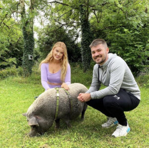 Couple walking a pig